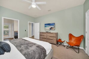 A bedroom with a bed, a dresser, a chair, and a ceiling fan. - Star Wars Game Room • Harry Potter Room • Projection Screen • Pool • Near Disney (Kissimmee)