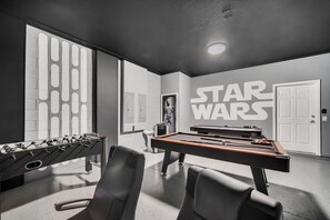 A modern room with a foosball table, pool table, and Star Wars-themed decor. - Star Wars Game Room • Harry Potter Room • Projection Screen • Pool • Near Disney (Kissimmee)