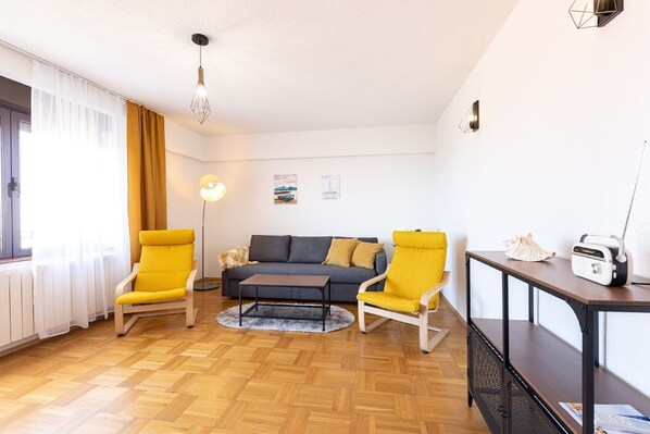 A living room with a sofa, two yellow armchairs, a coffee table, a lamp, and a radio on a table. - Apartment Bella Dalia (Solin)