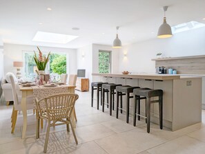 Enjoy meals in this well-appointed kitchen and dining area, featuring a central island with bar stools and a dining table for two.