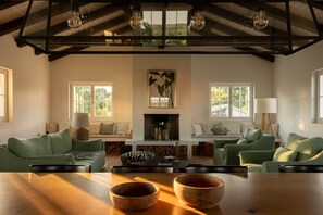 A spacious living room with a high ceiling, a fireplace, and a large window overlooking a landscape. - Casa Conte Istria, Casa Conte Istria - Luxuriöses Ferienhaus im Herzen Istriens (Barat)