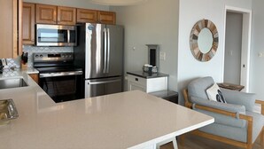 A modern kitchen with stainless steel appliances, wooden cabinets, and a large island.