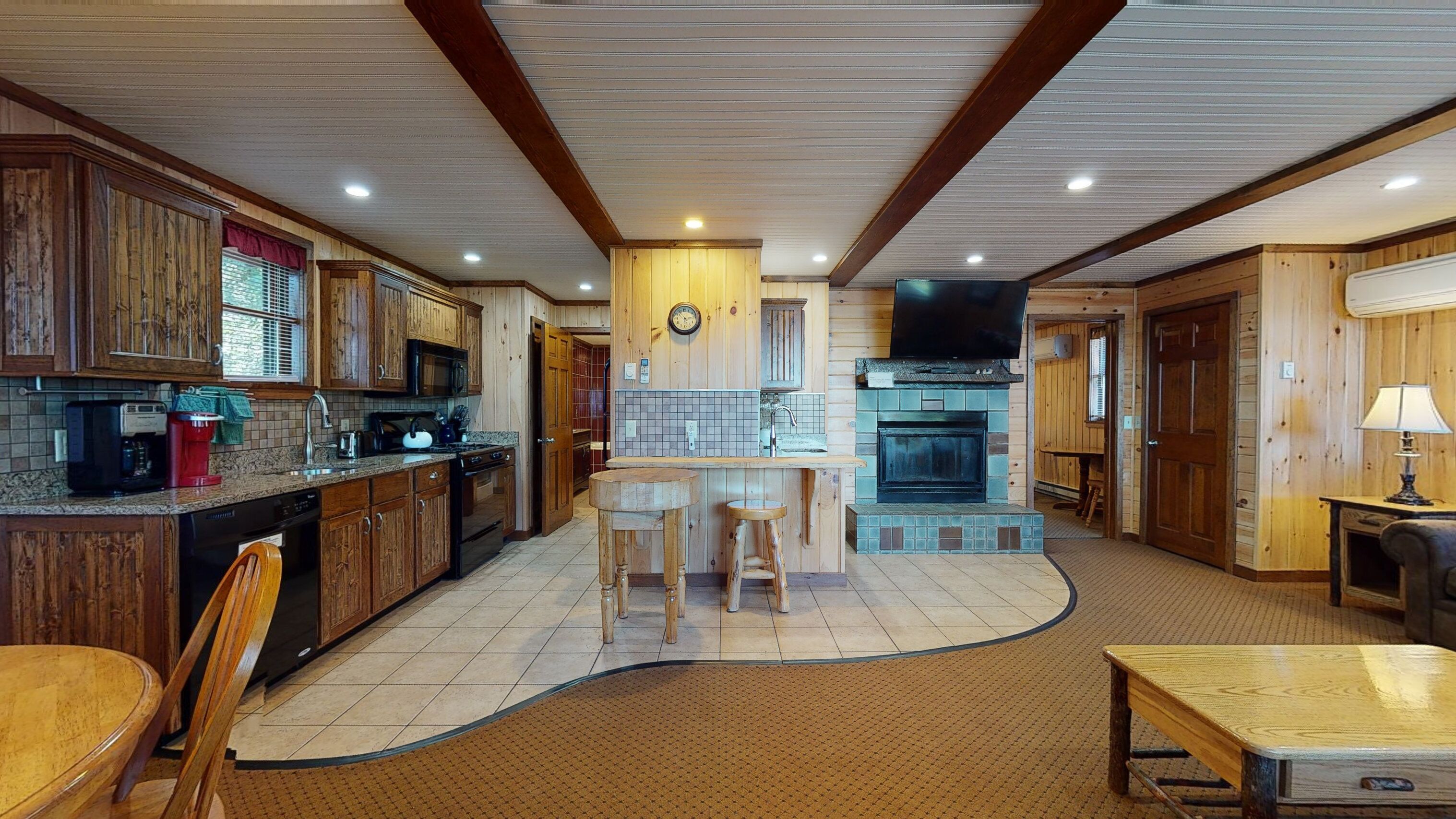 A spacious kitchen with wooden cabinets, a central island, and a built-in fireplace.