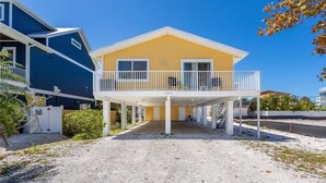 Ein zweistöckiges Haus mit überdachter Veranda und Balkon.
