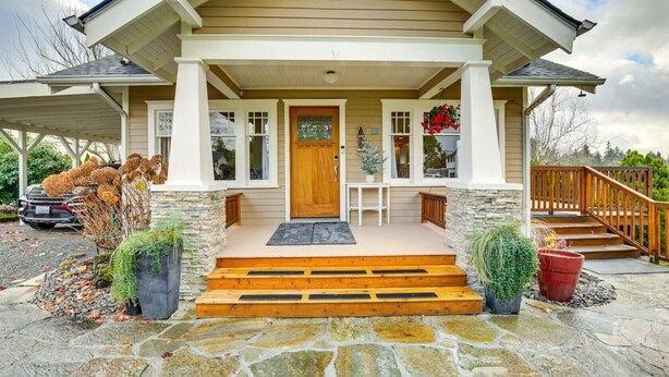 A house with a stone foundation, a wooden front porch, and a staircase leading to the entrance. - Sequoia Vacation Rental (Milton)