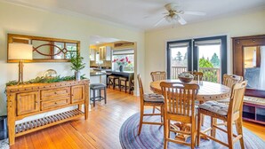 A dining area with a wooden table and chairs, a buffet cabinet, and a ceiling fan. - Sequoia Vacation Rental (Milton)