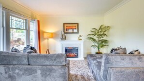 A living room with two grey sofas, a fireplace, a floor lamp, and a potted plant. - Sequoia Vacation Rental (Milton)