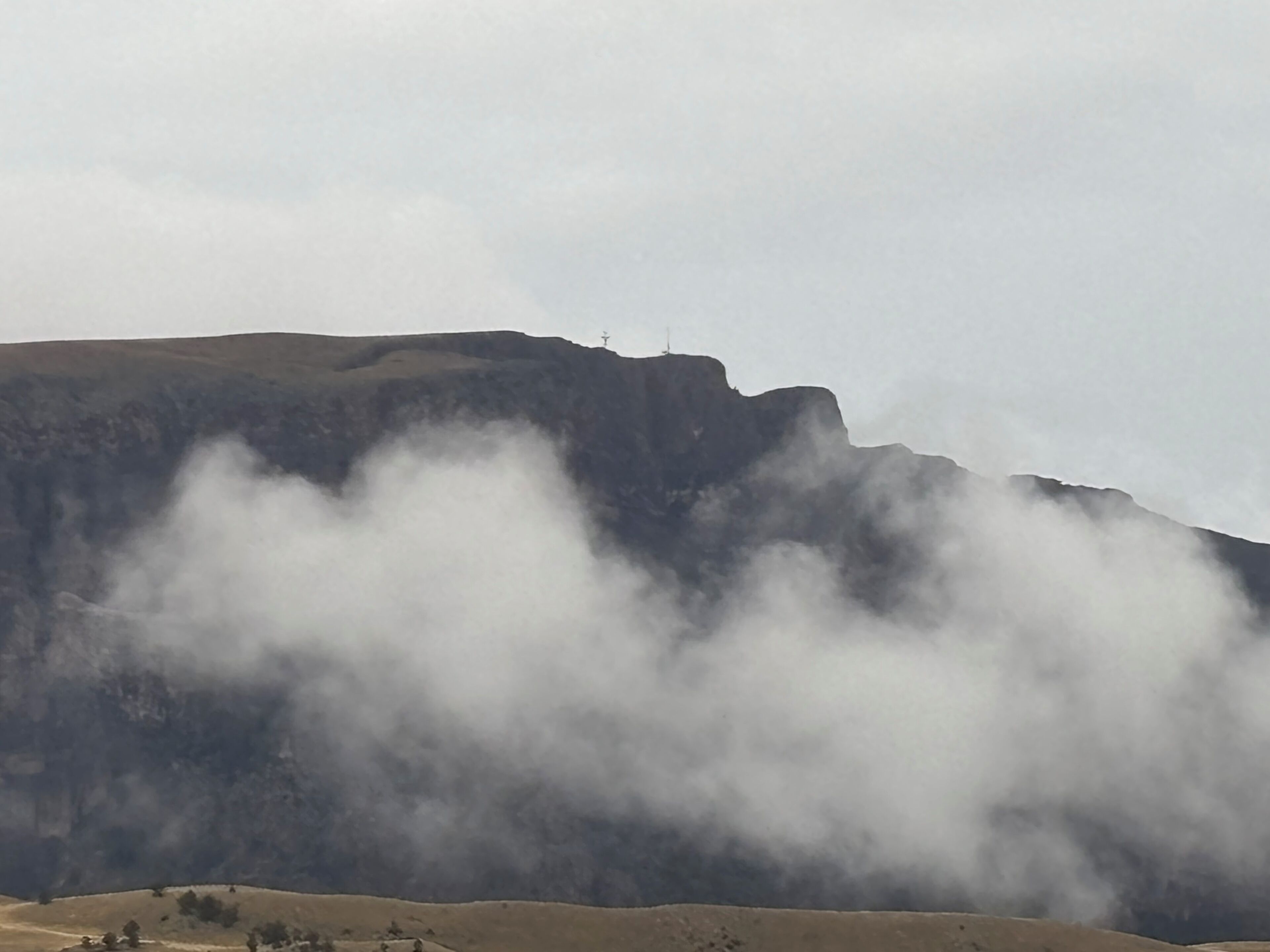A mountainous landscape with a prominent peak and a valley below.