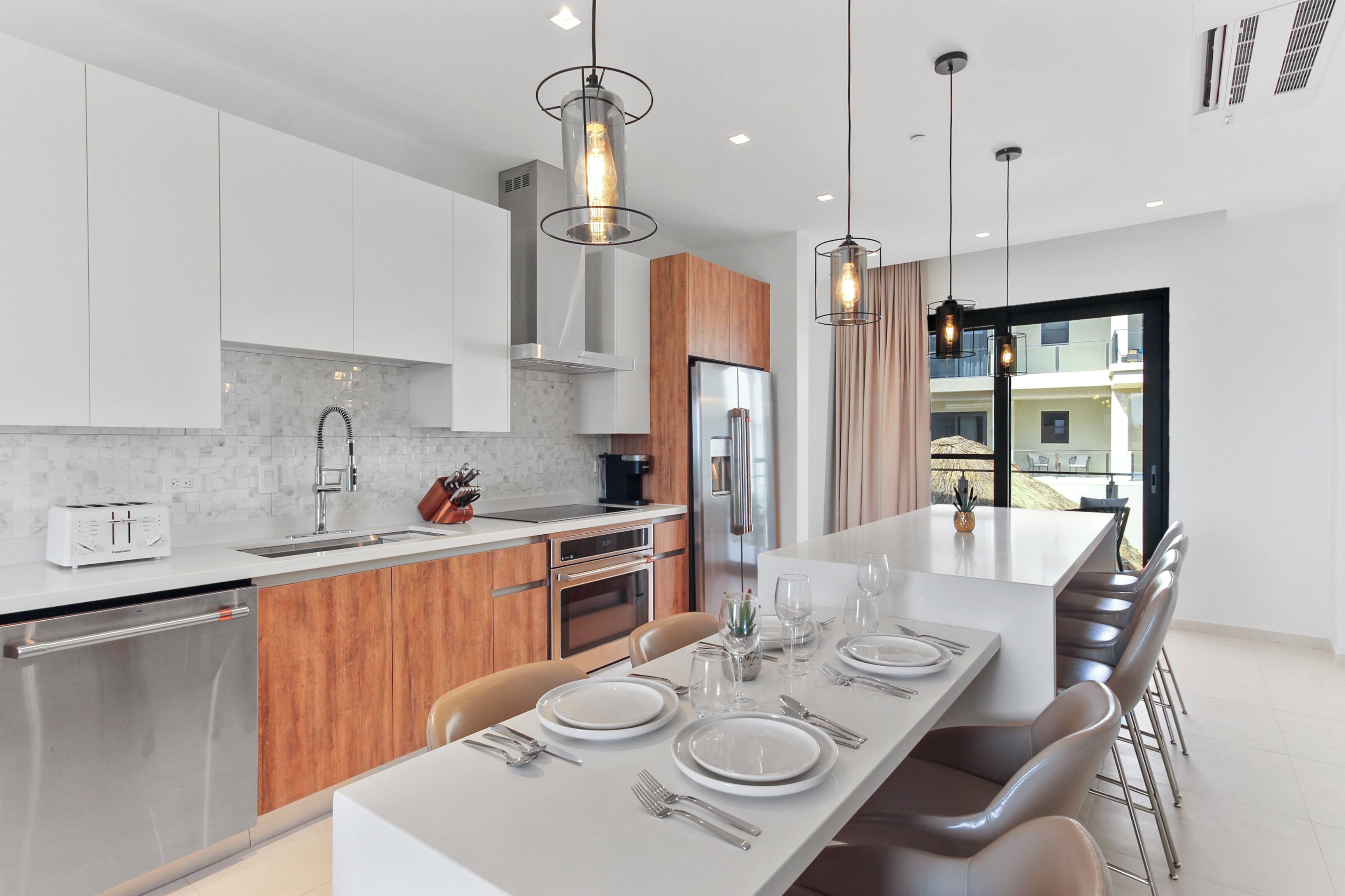 A modern kitchen with white cabinets, stainless steel appliances, and a central island with seating.
