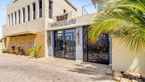 A building with a stone facade and a sign that reads "Warrior". - Bocobay Wariruri Condos (Noord)
