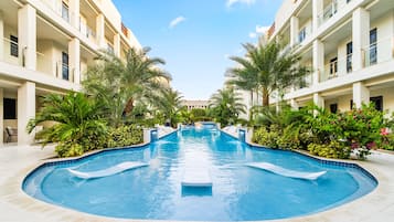 Een buitenzwembad, parasols voor strand/zwembad