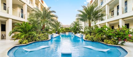 Una piscina al aire libre, sombrillas, tumbonas