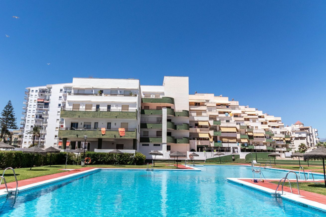 Un hôtel moderne doté d’une piscine et de nombreuses terrasses, avec une vue sur un ciel d’un bleu éclatant.