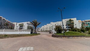 Un quartier résidentiel avec des immeubles modernes, une route asphaltée et un lampadaire.