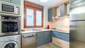 A modern kitchen with stainless steel appliances, a dishwasher, and a built-in washing machine. - Balcony with Sea View in Lambda 1 Apartment (Almuñécar)