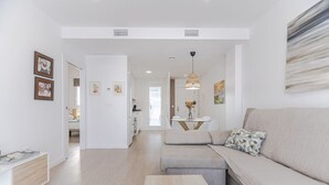 A modern living room with a sofa, coffee table, and artwork on the walls.