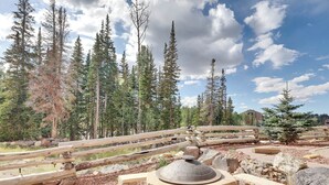 A rustic outdoor area with a stone bench, a circular brick structure, and a wooden bridge. - Two levels | Gas fireplace | Walk to ski slopes (Brian Head)