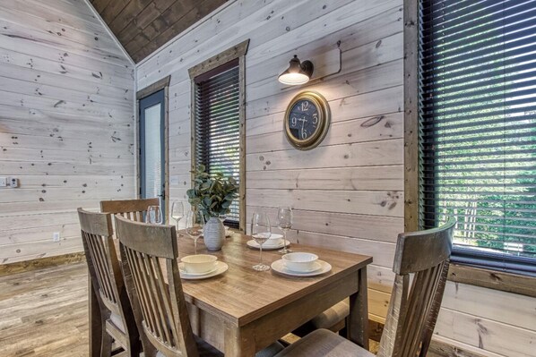 Enjoy meals in this cozy cabin-style dining area with a wooden table and chairs for four.