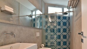 A modern bathroom with a large bathtub, a toilet, and a shower area.