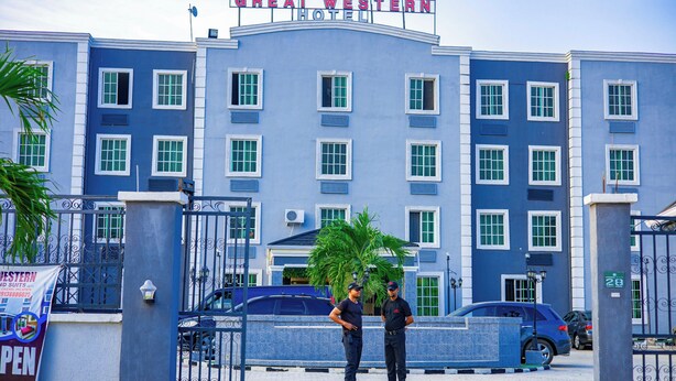 A hotel entrance with a sign reading "GREAT WESTERN HOTEL" and a gated driveway. - Great Western Hotel and Suites (Owerri)