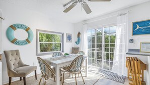 A dining area with a white table, four chairs, and a ceiling fan. - Reese's Beach Retreat on beautiful Anna Maria Island (Holmes Beach)