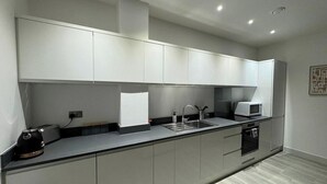 A modern kitchen with a built-in microwave, toaster, and sink.