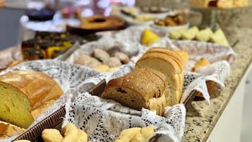 A variety of breads and pastries on a buffet table.