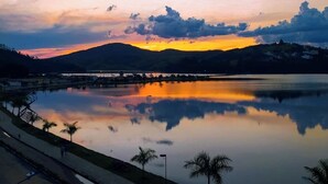 A calm lake reflecting the sunset with a bridge in the distance. - Lara's Hotel (Capitólio)