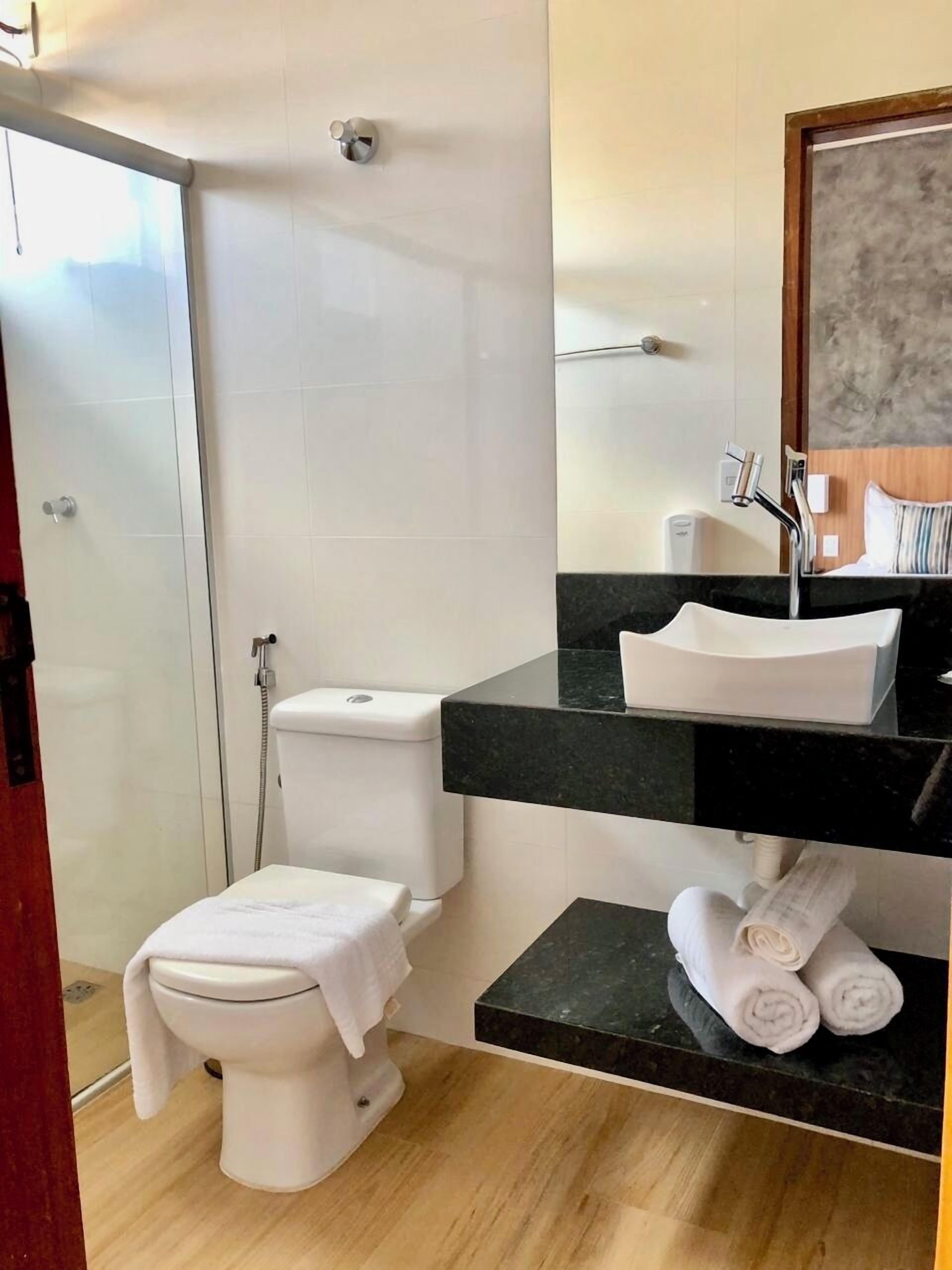 A modern bathroom with a toilet, sink, and shower.