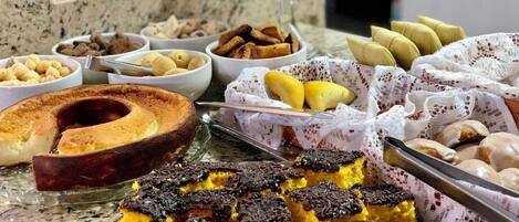 Un buffet proposant une variété de desserts, notamment des gâteaux, des pâtisseries et du pain.