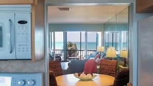 A kitchen with a microwave and a coffee maker, leading to a balcony with a view of the ocean. - Best View on Siesta Key 1 Bed 1 Bath Top Floor Steps to Beach (Siesta Key)
