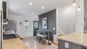 Eine moderne Küche mit einer Granit-Arbeitsplatte, einem eingebauten Herd und einem Essbereich mit Holzbänken.