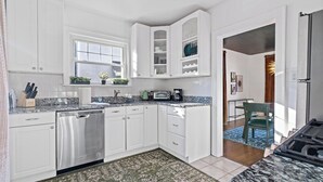A modern kitchen with white cabinetry, a dishwasher, a stove, and a microwave. - Peaceful Oakley Escape 2bd|Lg Priv Deck w views (Cincinnati)