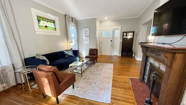 Un salon comprenant un canapé, des fauteuils, une table basse, une cheminée et un téléviseur.