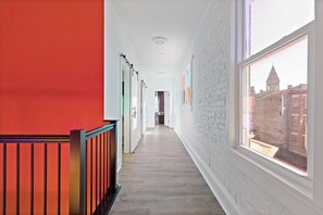 Corridors lead to a door at the end, offering a glimpse of the city view.