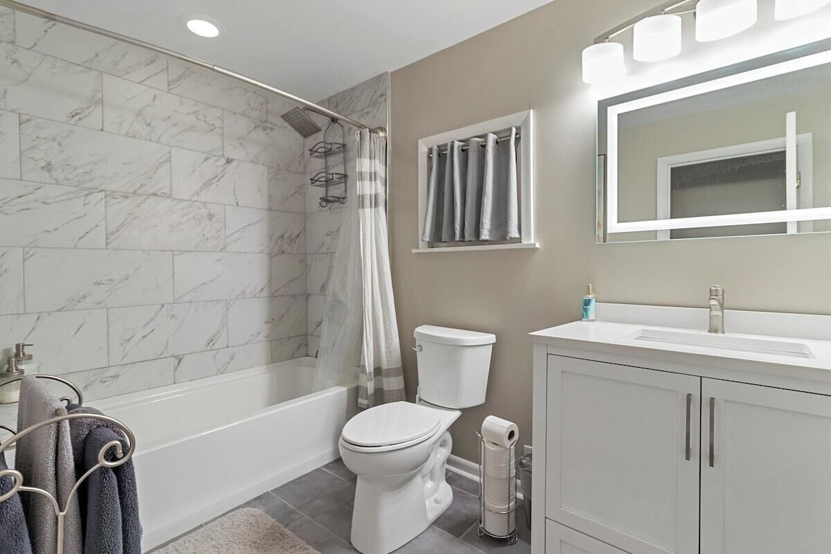 Une salle de bain moderne équipée d’une douche, de toilettes et d’un lavabo.