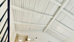 Eine geräumige Küche mit Holzschränken, einem großen Fenster und einer Treppe zu einer oberen Ebene.