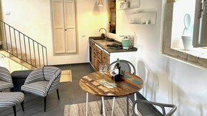 Ein kompakter Wohnraum mit Essbereich, Küche und Treppe.