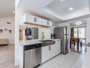 A modern kitchen with white cabinetry, stainless steel appliances, and a dishwasher.