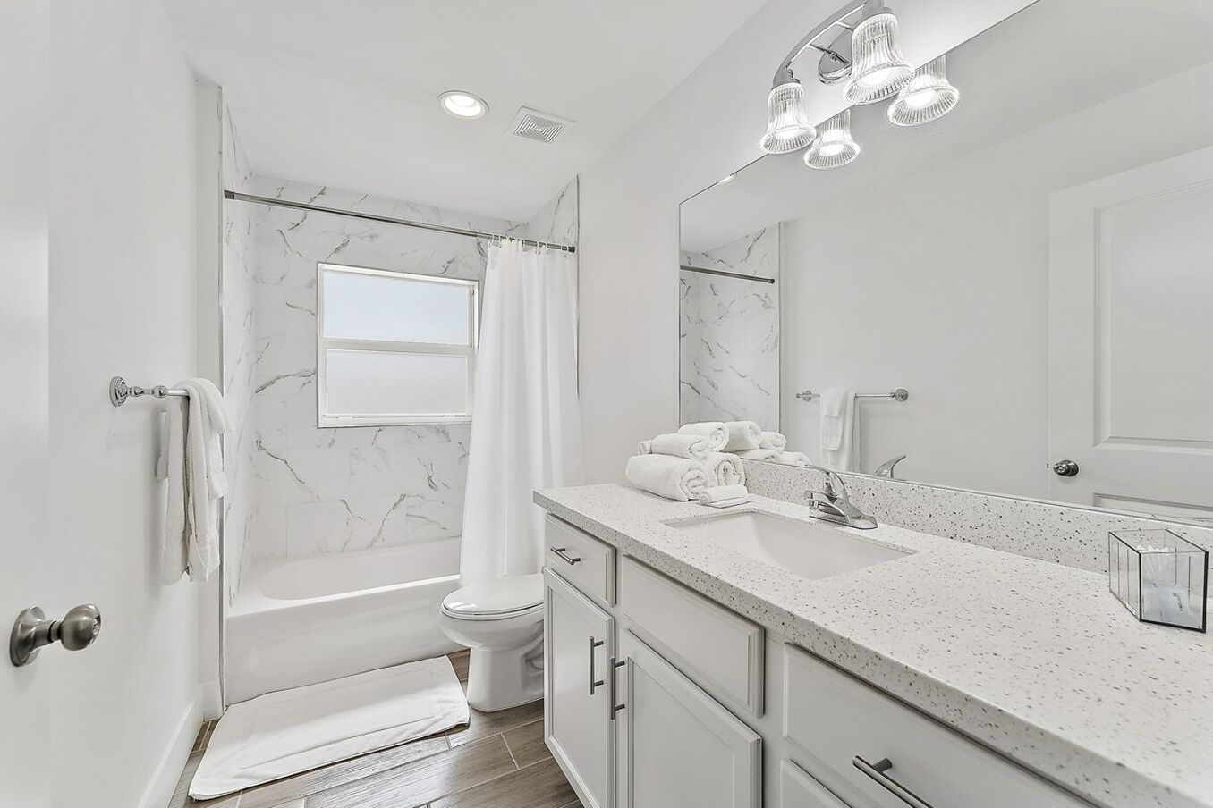 Un baño moderno con una bañera independiente, un espejo grande y un lavamanos con encimera.