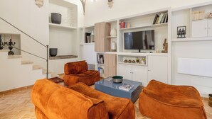 A living room with a fireplace, a TV, and a staircase. - Piazza Navona - Apartment with Authentic Fresco of the 1500s (Roma)