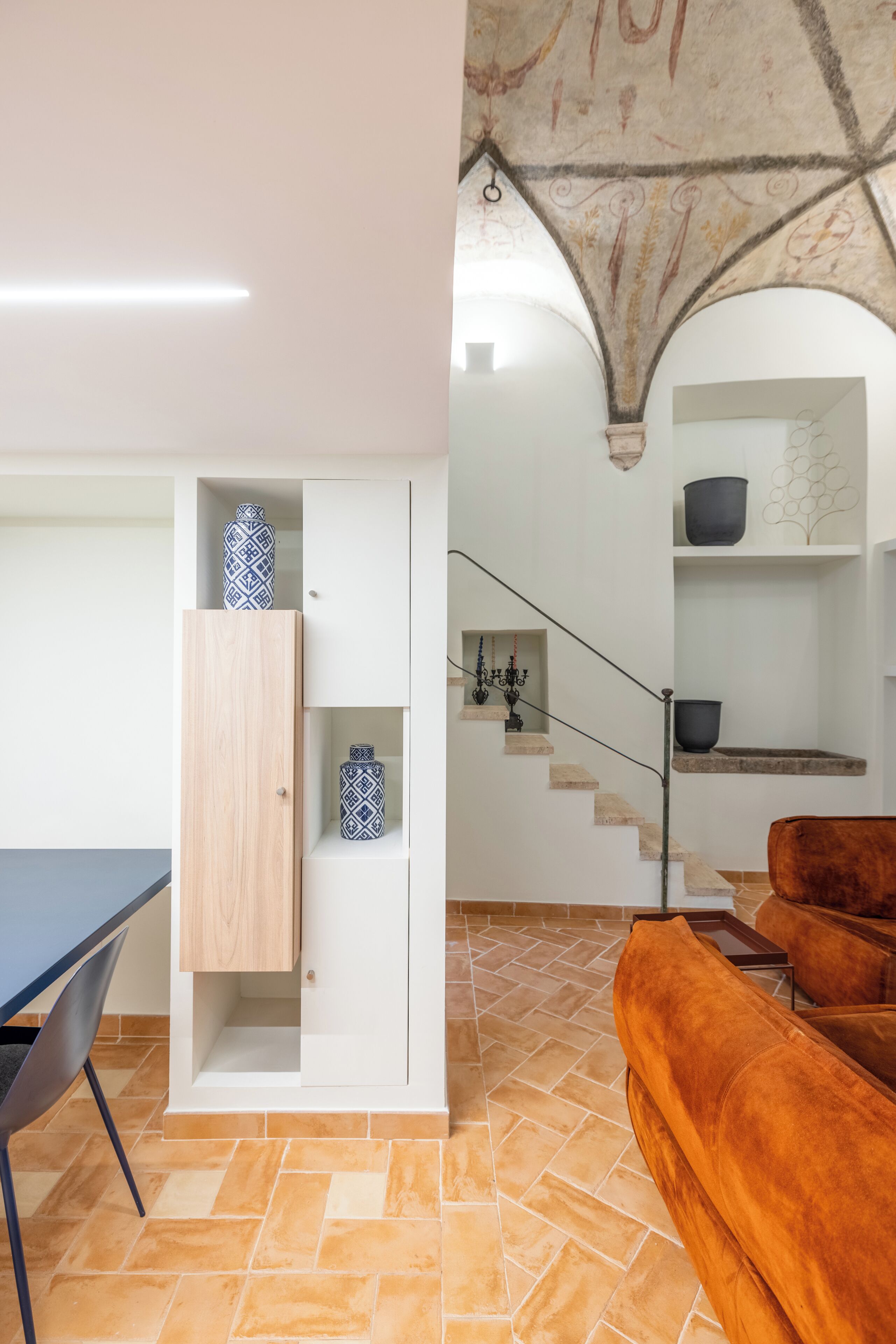 A modern interior with a dining area, a staircase, and a seating area.