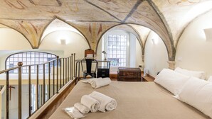 A room with a large bed, a desk, and a chair. There is a window with a view of the outside. - Piazza Navona - Apartment with Authentic Fresco of the 1500s (Roma)