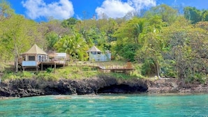 A coastal property with two buildings, a dock, and a rocky shoreline. - Waterfront Luxury Tented Experience with Saltwater Infinity Pool & Beach - 2 Bed (Vigie)