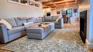 Una sala de estar moderna con un sofá modular, una mesa de centro y una alfombra grande.