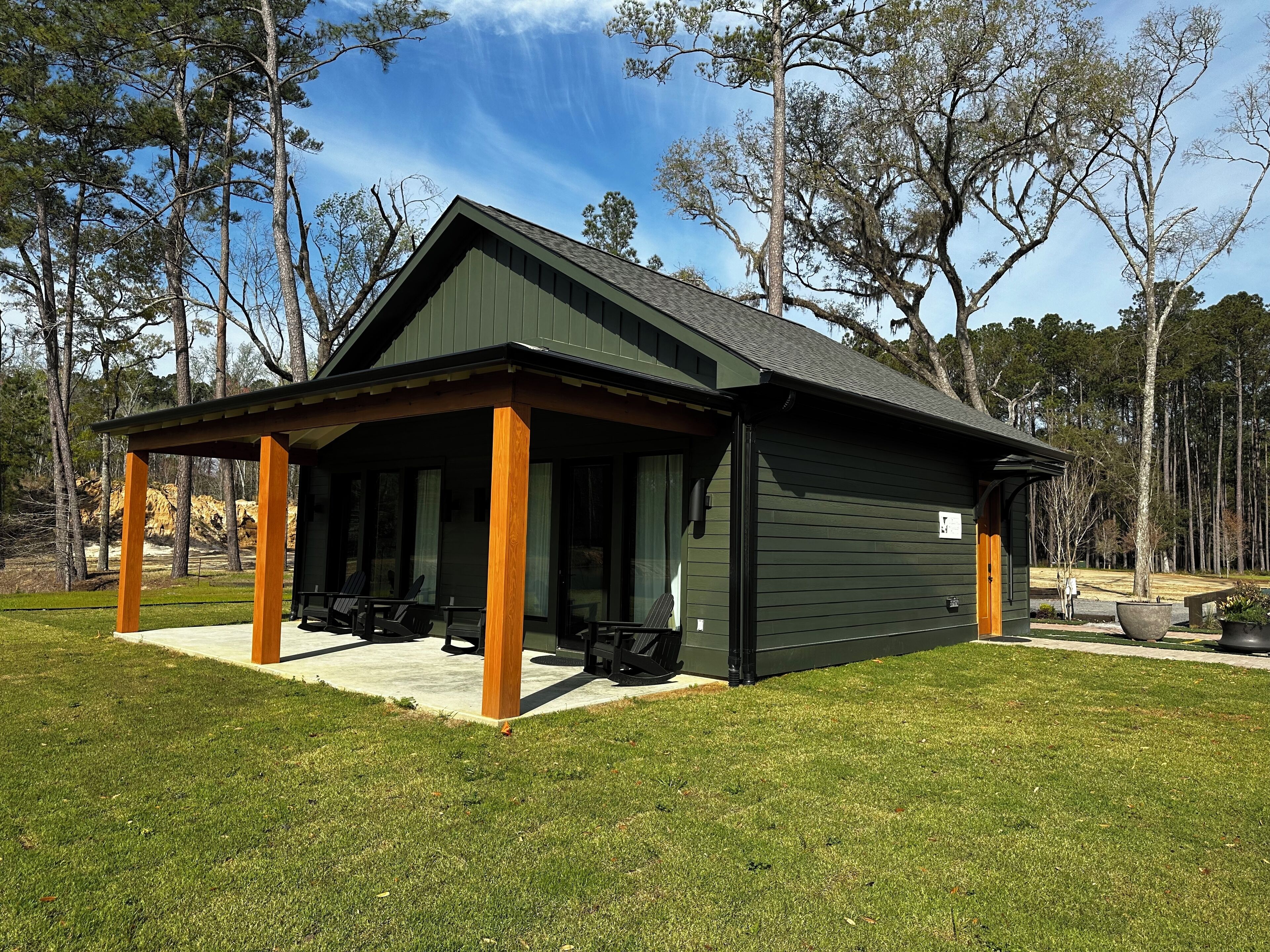 A lodge with a covered patio, outdoor seating, and a large window.
