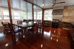 A spacious kitchen with a dining area, large windows, and a built-in stove. - Tropical House with Historic Charm, WiFi, Private Bathrooms and Workspaces (Panamá)