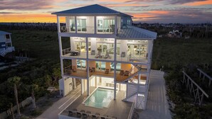 Una casa moderna de varios pisos con piscina, ventanas amplias y una terraza.