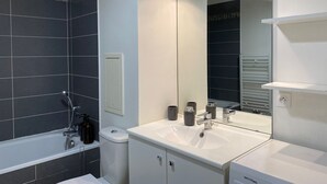 Un baño moderno con bañera, inodoro y lavamanos.