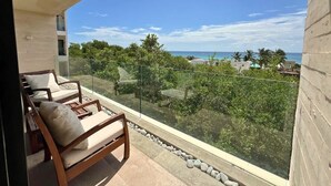 Un balcon offrant une vue dégagée sur l’océan et la végétation.